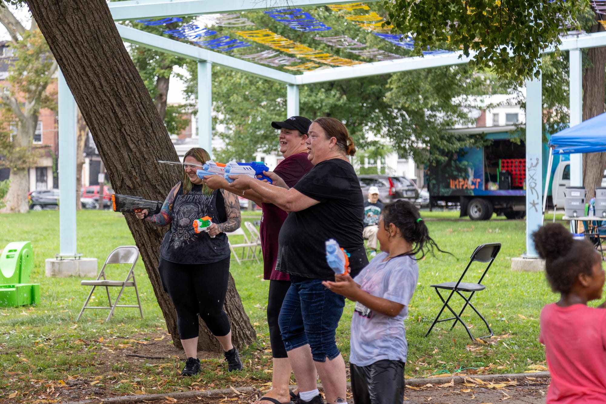 Photos of Kensington: Community members participate in the second annual "Community Water Gun Fight" in Harrowgate Park.